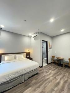 a bedroom with a large bed and a table at Silana Riverfront Danang in Da Nang