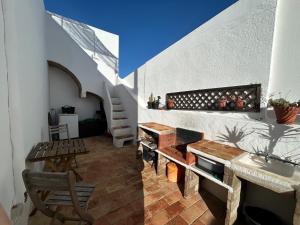 a living room with a table and a stair case at Casa do Levante in Olhão