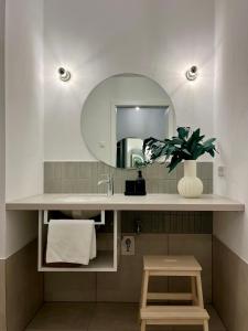 a bathroom with a sink with a mirror and a potted plant at Design Color Apartments Leer in Leer +51 photos