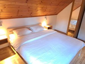 een slaapkamer met een groot wit bed met twee kussens bij Guesthouse Zafran in Smoljanac