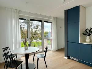 a dining room with a table and chairs and a window at Design Color Apartments Leer in Leer