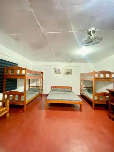a room with two bunk beds and a ceiling at La Casa Blanca Binoclutan in Botolan