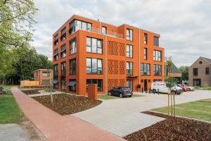 an orange brick building on a city street at Design Color Apartments Leer in Leer