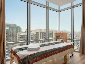 a bedroom with a bed in front of a large window at Novotel Dubai Gold District in Dubai