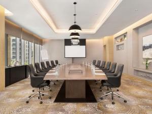 a conference room with a large table and chairs at Novotel Dubai Gold District in Dubai