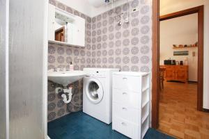 a bathroom with a washing machine and a sink at WI-RO Mavignola - Trekking & Ski in Madonna di Campiglio