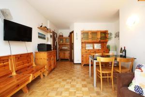 a living room with a table and a television at WI-RO Mavignola - Trekking & Ski in Madonna di Campiglio