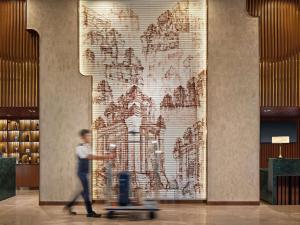 a man walking in front of a wall with a mural at Mercure Nha Trang Beach in Nha Trang