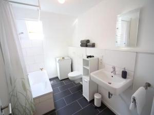 a white bathroom with a sink and a toilet at Hofhaus Land-Idylle in der Stadt in Mainz +12 photos