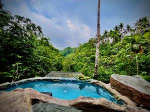 uma piscina no meio de uma floresta em Cabin swargana em Tampaksiring