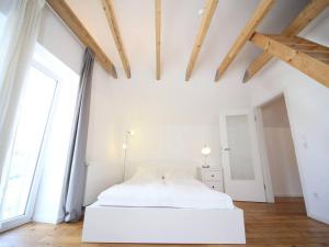 a bedroom with a white bed and a large window at Hofhaus Land-Idylle in der Stadt in Mainz