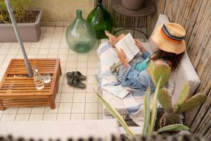 uma mulher sentada num sofá a ler um livro em BrezadouraHouse, a due passi dal mare e dal centro em Rimini mais 14 fotografias