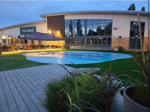Un gran edificio con una piscina en frente. en Billing Aquadrome Holiday Park Fishing Lakes Gold Caravan, en Great Billing