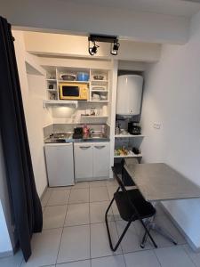 a small kitchen with an open refrigerator and a table at SWEET HOMES I Studio de Tata I Parking Gratuit in Angoulême