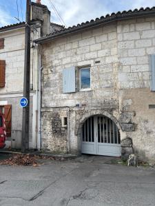 an old stone building with a white door at SWEET HOMES I Studio de Tata I Parking Gratuit in Angoulême