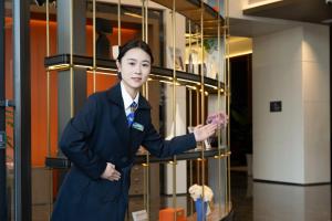 a woman standing in front of a display case at Hampton by Hilton Hefei Xinqiao International Airport in Hefei