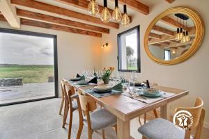 Un comedor con una mesa y sillas y un espejo. en Villa valerie, en Locmaria