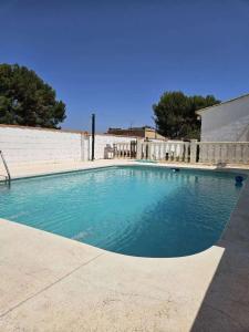 einem Pool mit blauem Wasser vor einem Gebäude in der Unterkunft Sunshine Courtyard, Villa independiente en Valencia in Lliria