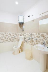 a bathroom with a toilet and a sink at Hotel Old Manali - Balcony Rooms with Mountain View, Garden & Parking in Manāli