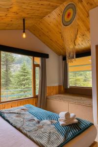 a bedroom with a bed and a large window at Hotel Old Manali - Balcony Rooms with Mountain View, Garden & Parking in Manāli