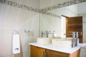 a bathroom with two sinks and a mirror at Keleo Safari Lodge in Bela-Bela