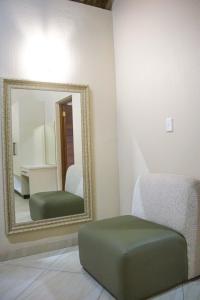a mirror and a green ottoman in a room at Keleo Safari Lodge in Bela-Bela