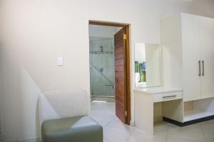 a bathroom with a chair and a sink and a shower at Keleo Safari Lodge in Bela-Bela