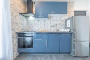 a kitchen with blue cabinets and a refrigerator at Maison calme, lumineuse & design in Sevran +14 photos