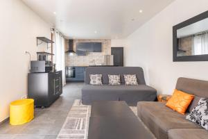 a living room with a couch and a bed in it at Maison calme, lumineuse & design in Sevran