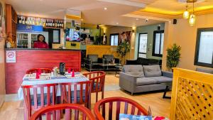 a restaurant with a table and chairs and a woman at ALICIA HOTEL in Douala