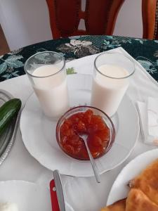 a table with a bowl of food and two glasses of milk at Villa GJOKA in Berat