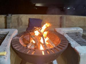 - un foyer extérieur en briques avec flammes dans l'établissement Swell Eco Lodge, à Mdumbi