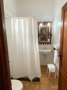 a bathroom with a white shower curtain and a sink at Waingunga in Lepe