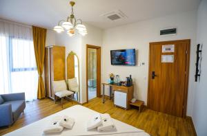 una habitación con una cama y un sofá y una mesa en Hotel Fantazia Oradea - Self Check In & Out, en Oradea