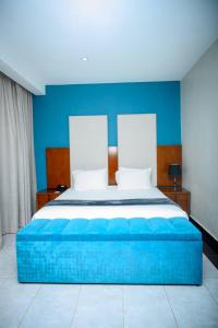a bedroom with a large bed with a blue wall at Lifestyle Boutique Hotel in Lilongwe +2 photos
