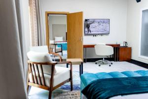 a bedroom with a bed and a desk and chairs at Lifestyle Boutique Hotel in Lilongwe