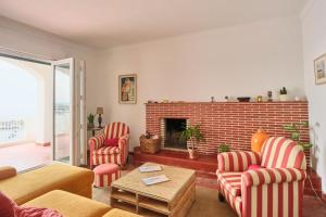 a living room with chairs and a brick fireplace at Manas Slowliving - Sines in Sines