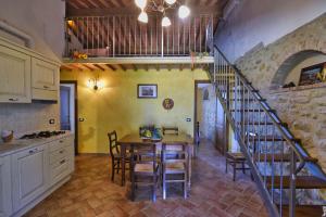 VillamagnaにあるAgriturismo Pompiliaのテーブルと階段のあるキッチンとダイニングルーム