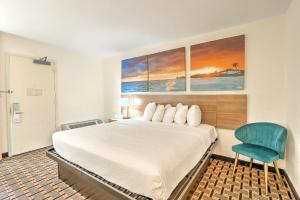 a hotel room with a bed and a blue chair at Hotel Carolina - Standard King Room in Hilton Head Island