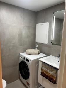a bathroom with a washing machine and a sink at Apartment right by Karmsund in Karmøy +1 photo