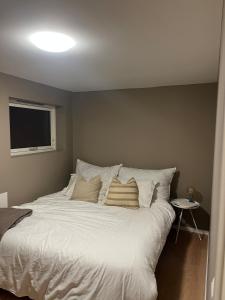 a bedroom with a large white bed with pillows at Apartment right by Karmsund in Karmøy