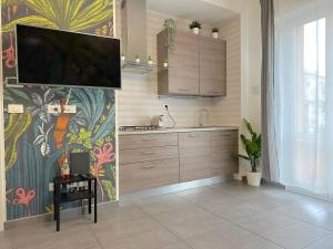 una cucina con una TV su una parete con un murale di Villa Laura Home a Bologna