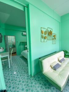 een blauwe kamer met een bank en een tafel bij Luigi Guest House & Kitchen in Sattahip