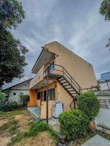 een huis met een trap aan de zijkant bij Luigi Guest House & Kitchen in Sattahip