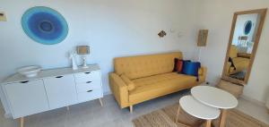 a living room with a yellow couch and a table at Sea View Appartement Blue Monkey in Ifach +15 photos