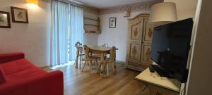 a living room with a table and a red couch at Golf Hotel Carezza in Carezza al Lago