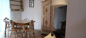 a kitchen with a table and chairs and a refrigerator at Golf Hotel Carezza in Carezza al Lago