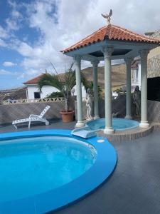 einen Pool mit einem Pavillon auf einer Terrasse in der Unterkunft Villa Costa Adeje in Adeje