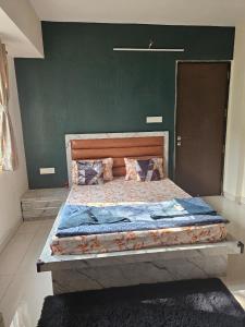 a large bed in a room with a green wall at StayGinie Baner in Pune +4 photos
