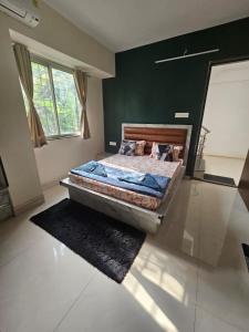 a bedroom with a bed and a green wall at StayGinie Baner in Pune